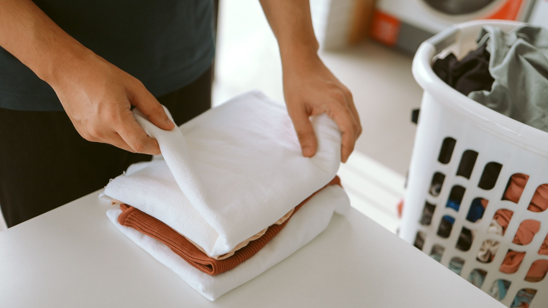 Man doing launder holding basket with dirty laundry of the washing machine in the public store. laundry clothes concept